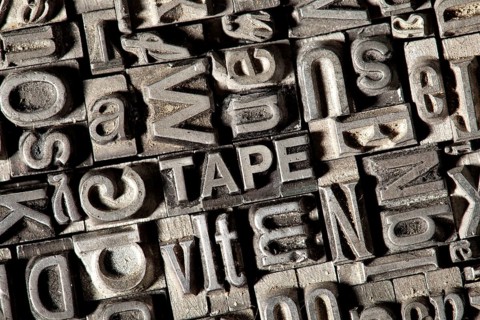 Old lead letters forming the word TAPE