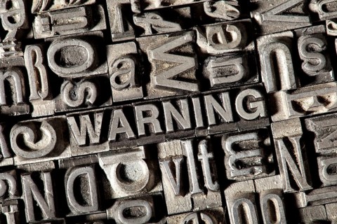 Old lead letters forming the word WARNING