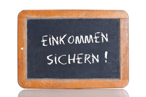 Old school blackboard with the words EINKOMMEN SICHERN!