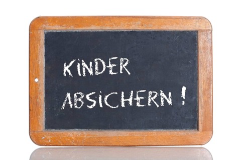 Old school blackboard with the words KINDER ABSICHERN!