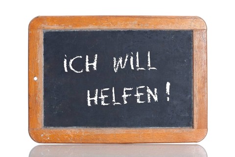 Old school blackboard with the words ICH WILL HELFEN!