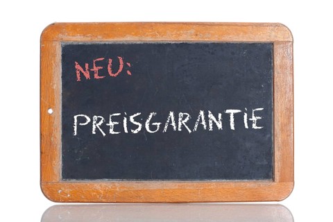 Old school blackboard with the words NEU: PREISGARANTIE