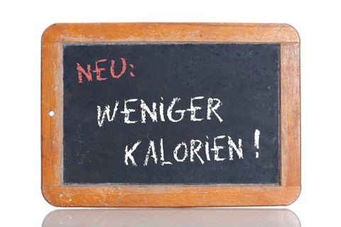 Old school blackboard with the words NEU: WENIGER KALORIEN!