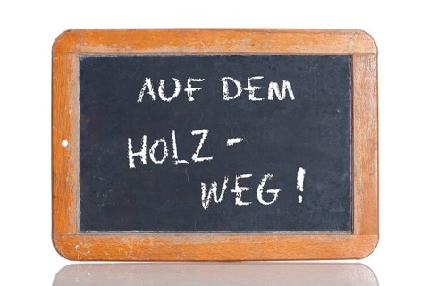 Old school blackboard with the term AUF DEM HOLZWEG
