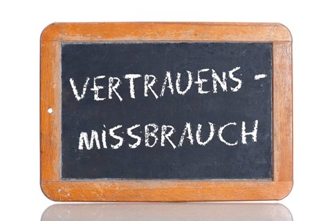 Old school blackboard with the term VERTRAUENSMISSBRAUCH