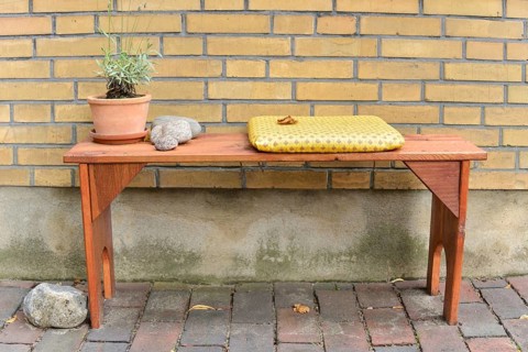 Bench seat with a cushion and a flower pot