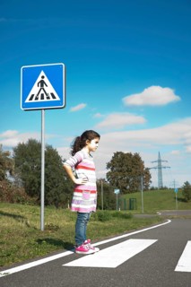 Girl waiting at a zebra crossing