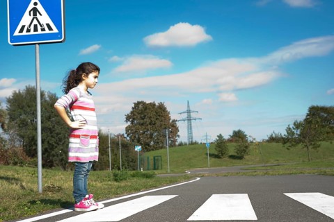 Girl waiting at a zebra crossing