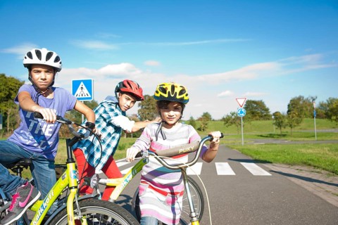 Children wearing bike helmets at a traffic awareness course