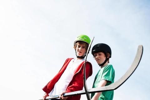 Two cool boys playing roller hockey with hockey sticks