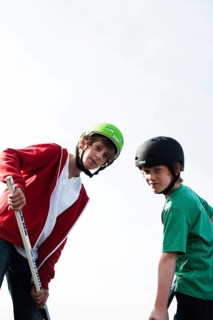 Two cool boys playing roller hockey with hockey sticks