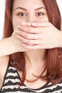 Young woman covering mouth with hands