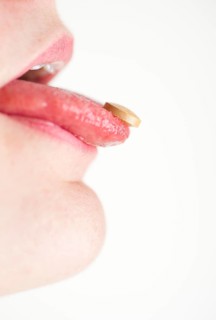 Woman with a pill on her tongue