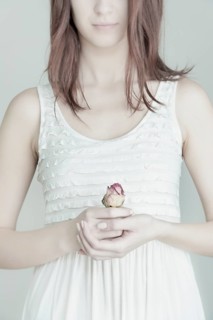Young woman holding a rose in her hands