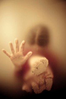 Woman looking down and holding a teddy bear