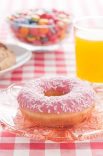 Donut with sprinkles and a glass of orange soda