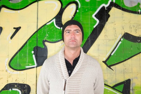 Man standing in front of wall covered with graffiti