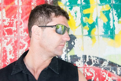 Portrait of a man standing in front of wall covered with graffiti