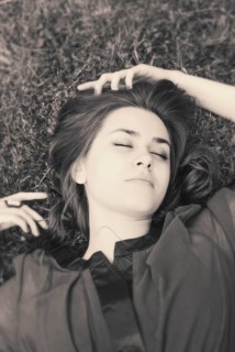 Young woman with closed eyes lying on grass