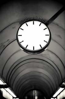 Empty clockface in a deserted walkway tunnel