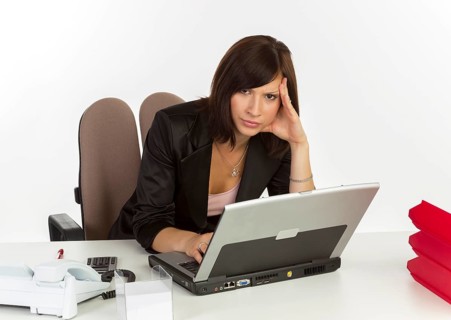 Young woman with a laptop sitting at a desk