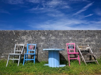 Colourful group of seats against a wall with an old cable drum as a table