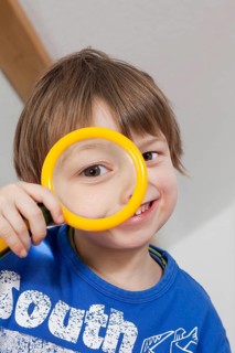 Boy looking through a magnifying glass