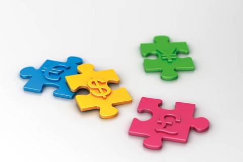 Pieces of a puzzle with different currency symbols