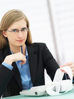 Businesswoman wearing glasses and using a calculator
