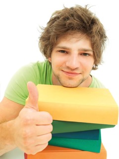 Young male student with a stack of books making a thumbs up gesture