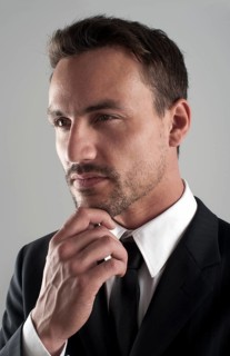 Young businessman wearing a suit with his hand on his chin
