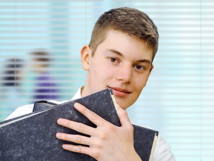 Apprentice or trainee holding files in an office