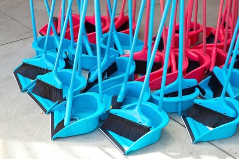 Blue and red brooms with shovels