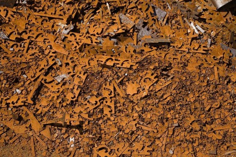 Assorted rusted metal brackets at a scrap metal recycling junkyard