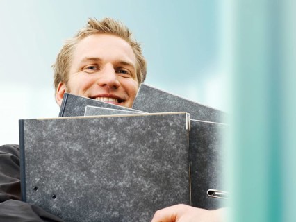 Businessman carrying ring binders