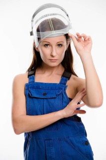 Woman wearing blue overalls and a protective helmet