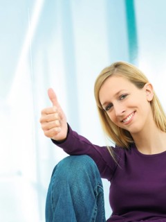Young woman making a thumbs up gesture
