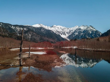 Snow-covered Japanese Alps reflected in Lake Taisho Pond