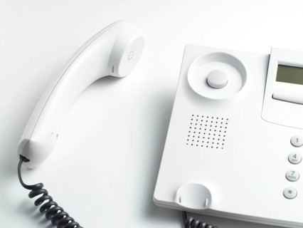 Handset laying beside a telephone