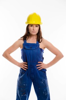 Woman wearing blue overalls and a hardhat