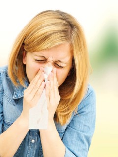 Young woman blowing her nose