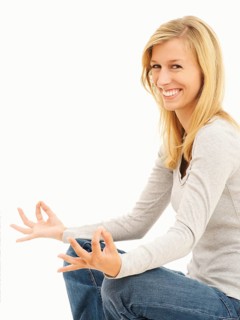 Woman smiling while meditating in a cross-legged position