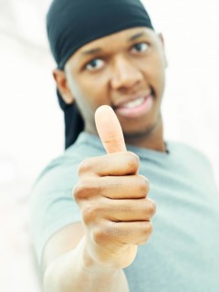 Dark-skinned man man wearing a bandana and making a thumbs up gesture