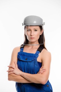 Woman wearing blue overalls and a protective helmet