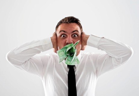 Desperate young man wearing a shirt and a tie holding his hands over his ears