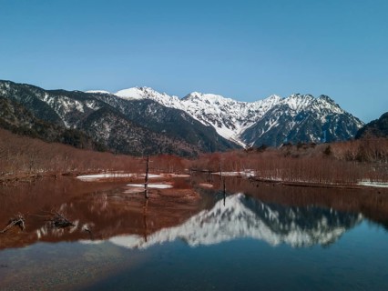 Snow-covered Japanese Alps reflected in Lake Taisho Pond