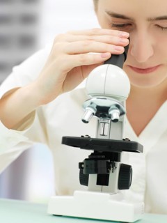 Scientist looking through a microscope