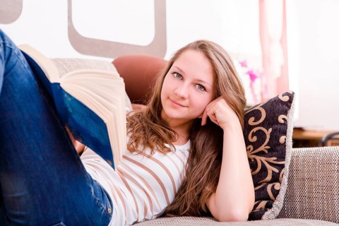 Girl reading a book on the sofa