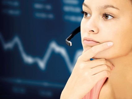 Businesswoman wearing a headset in front of a stock market curve