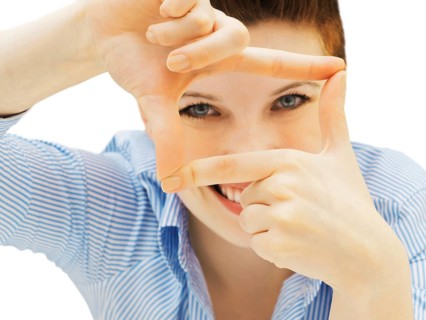 Businesswoman looking through her fingers as a frame